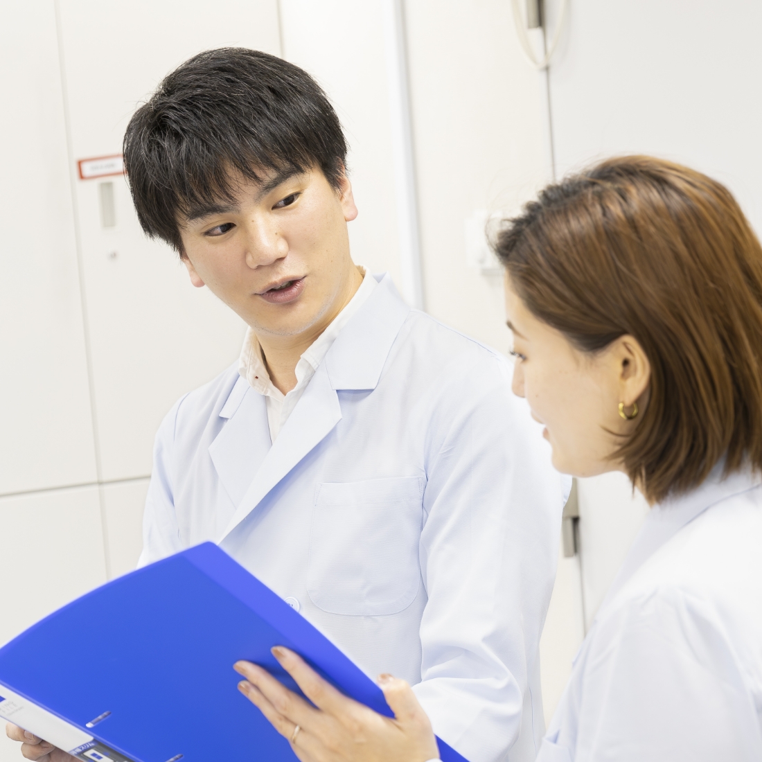 同僚と打ち合わせする野口さん写真